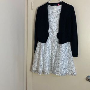 It’s a flower printed material and is black and white with a button sweater